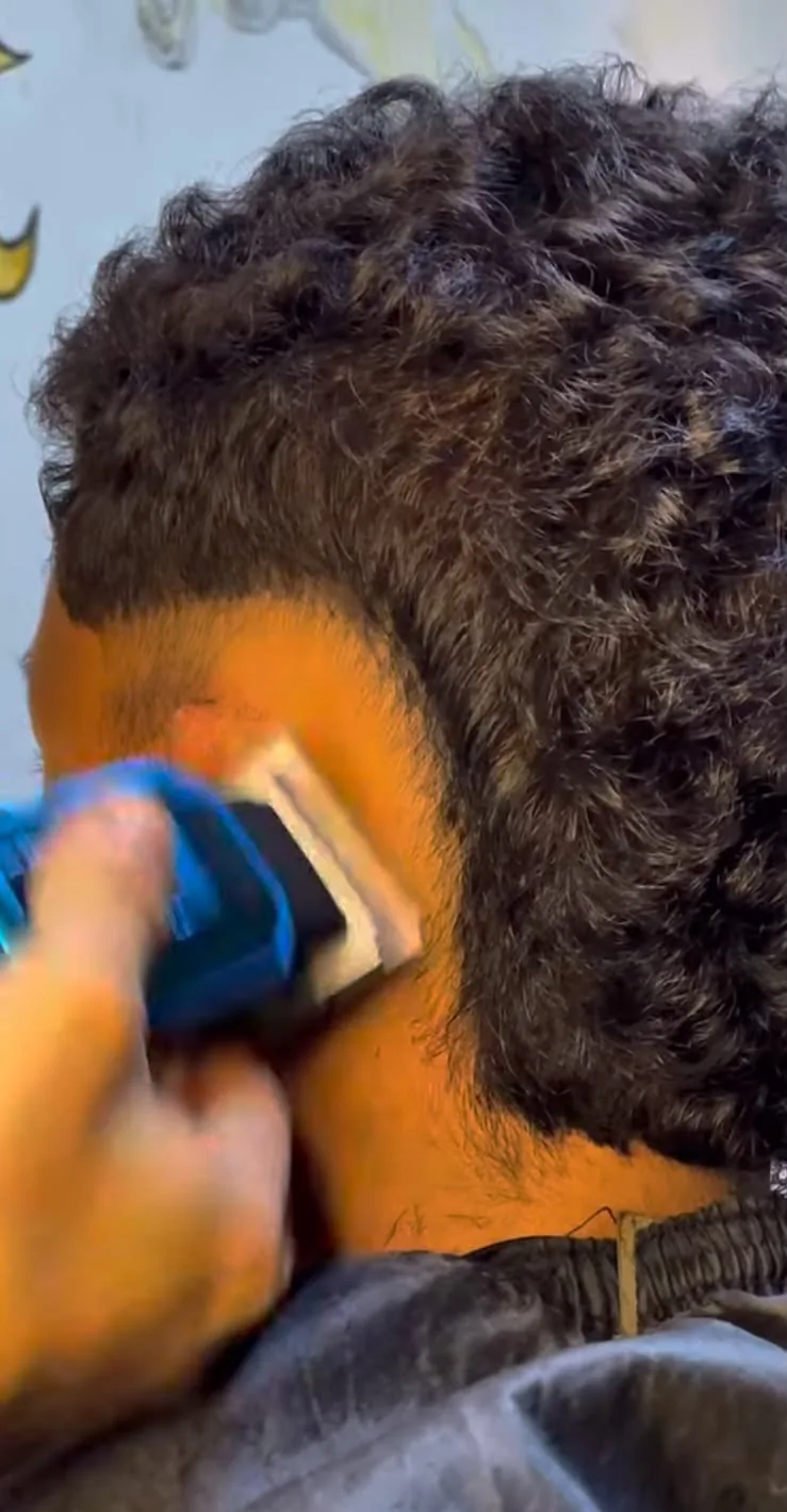 Acabamento de degradê em cabelo cacheado na Barbearia Nakamura
